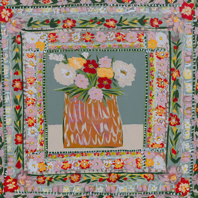 Woman holding a floral quilt with a field in the background